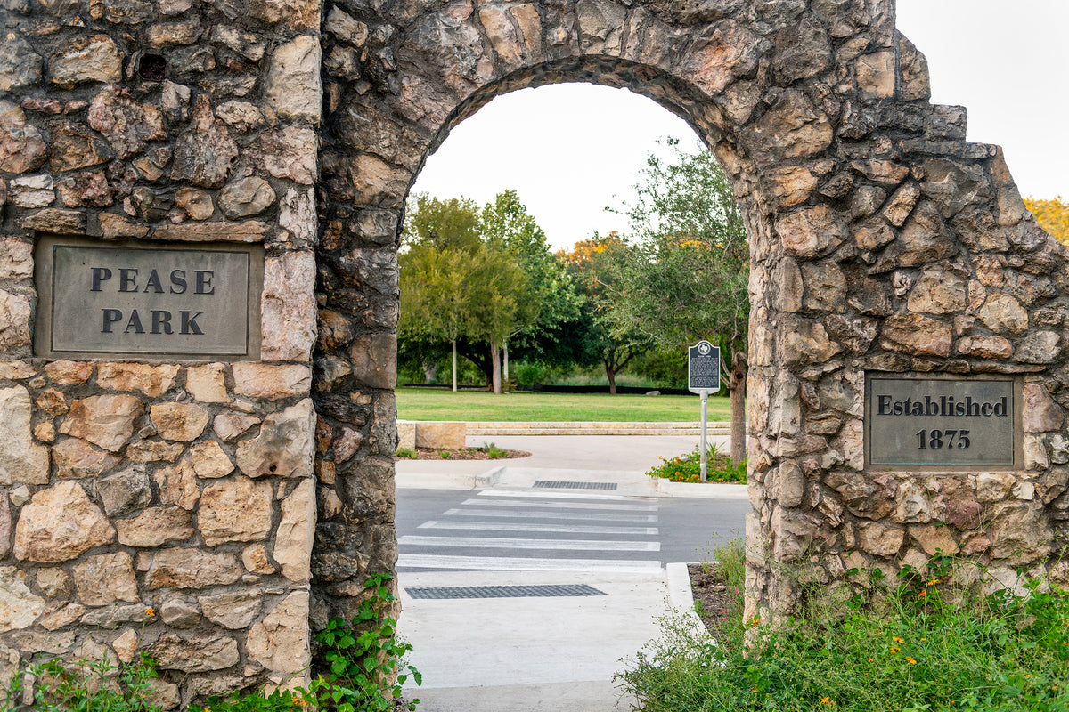 A stone gate arched gate frames the entrance to Pease Park