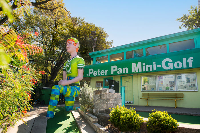 A giant Peter Pan kneels in front of Peter Pan Mini Golf